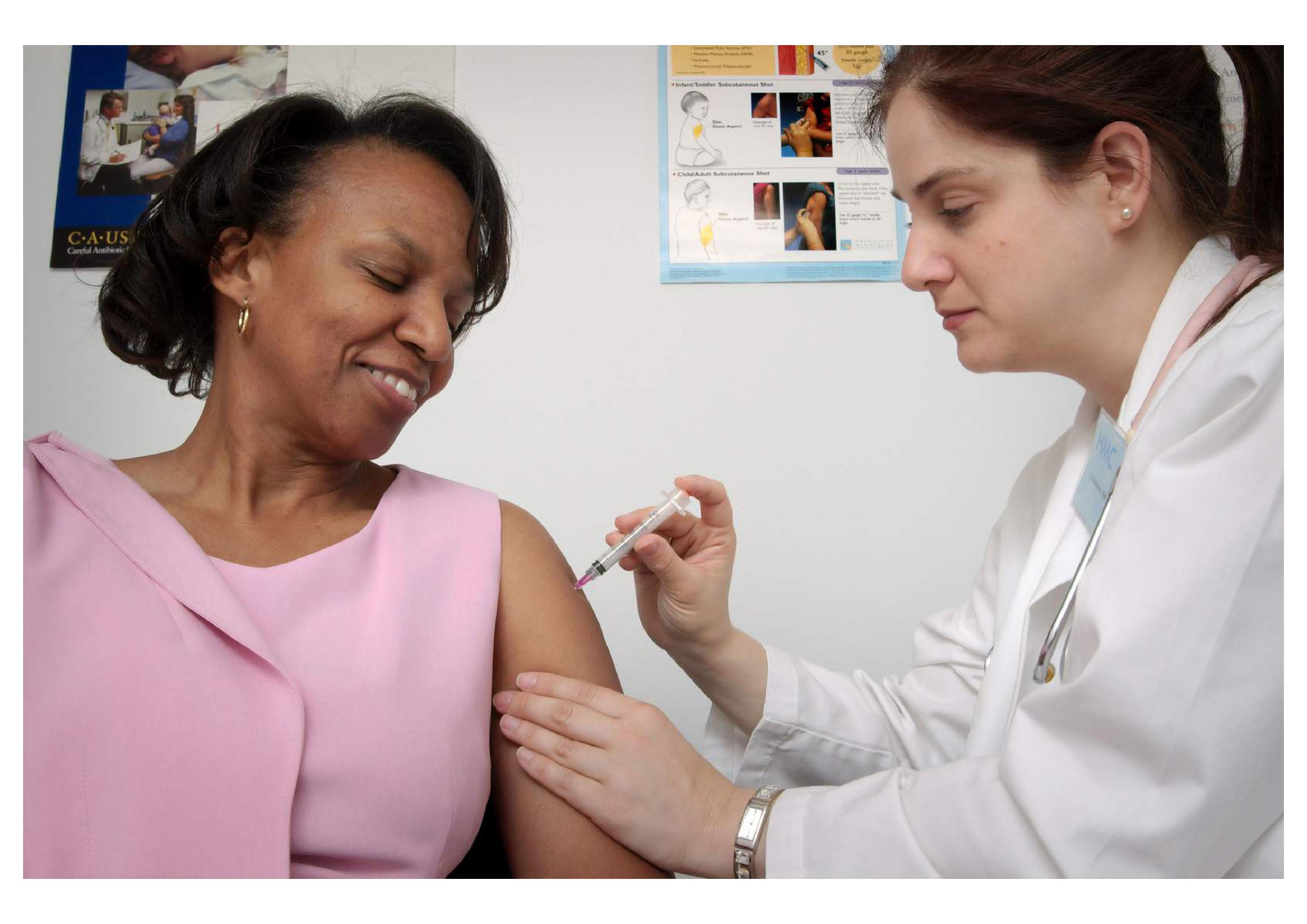 doctor giving a woman the flu vaccine
