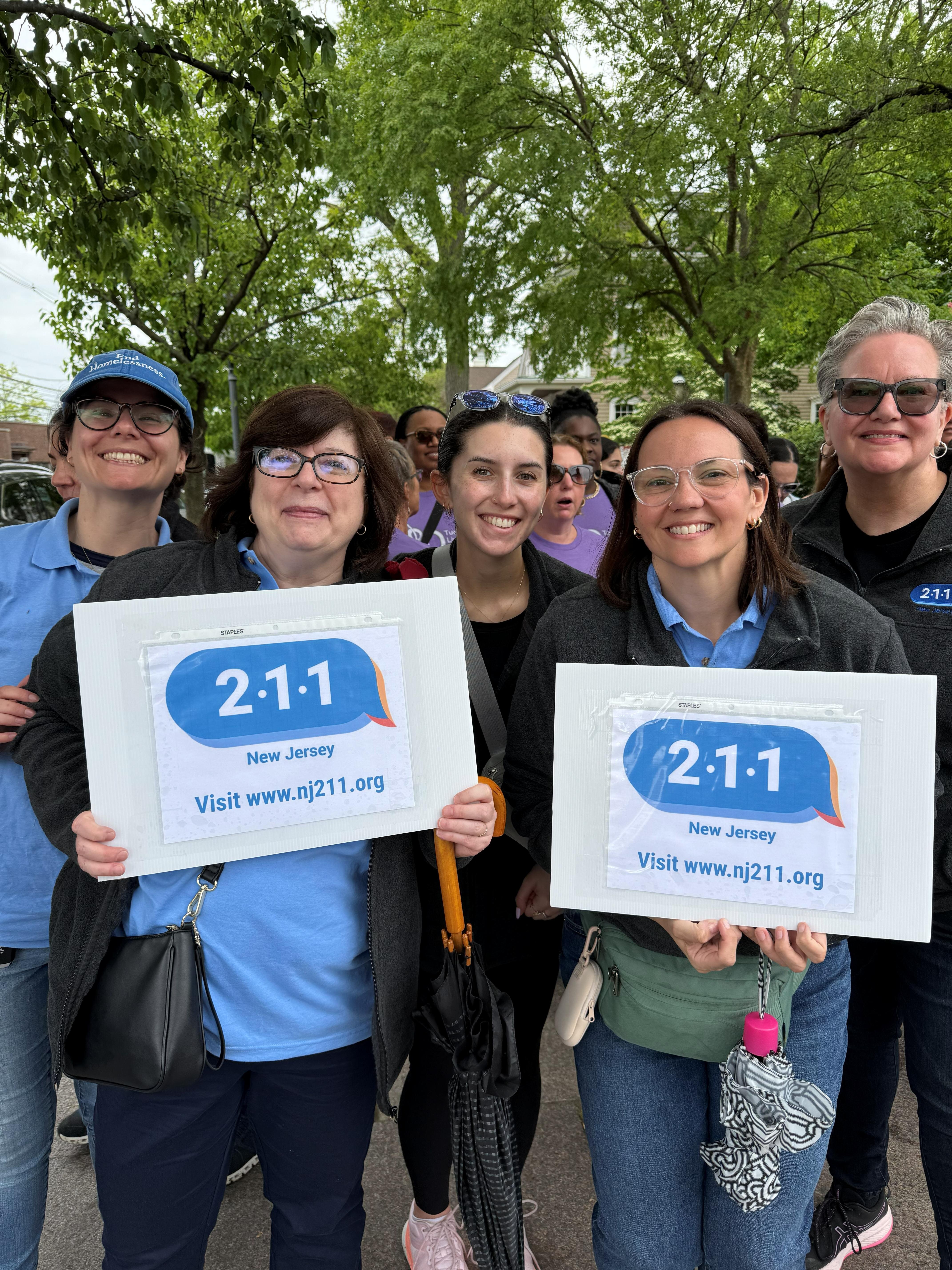 group of five women, two holding signs