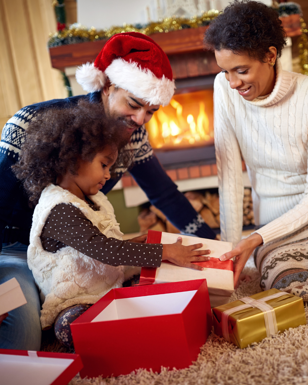 a family of three opening a single present