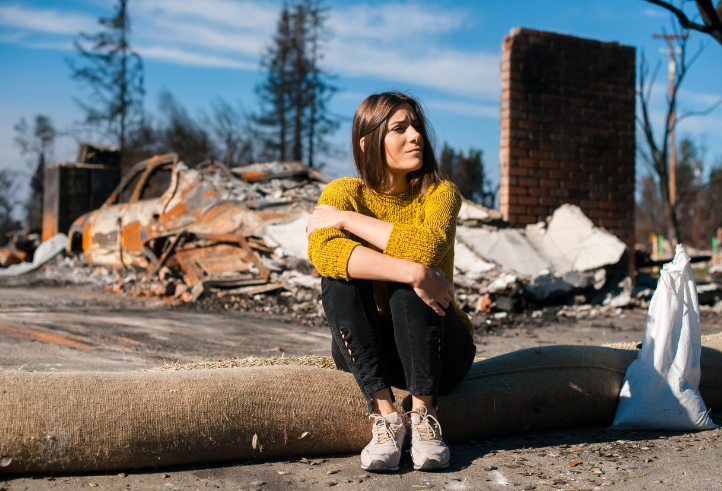 Woman sitting on crub after a disaster
