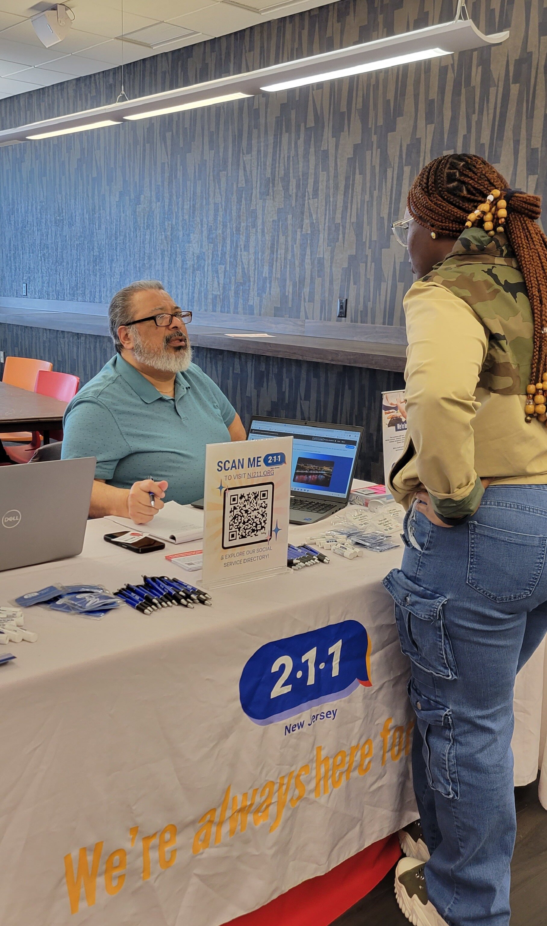 man sitting at table talks to woman who is standing facing him