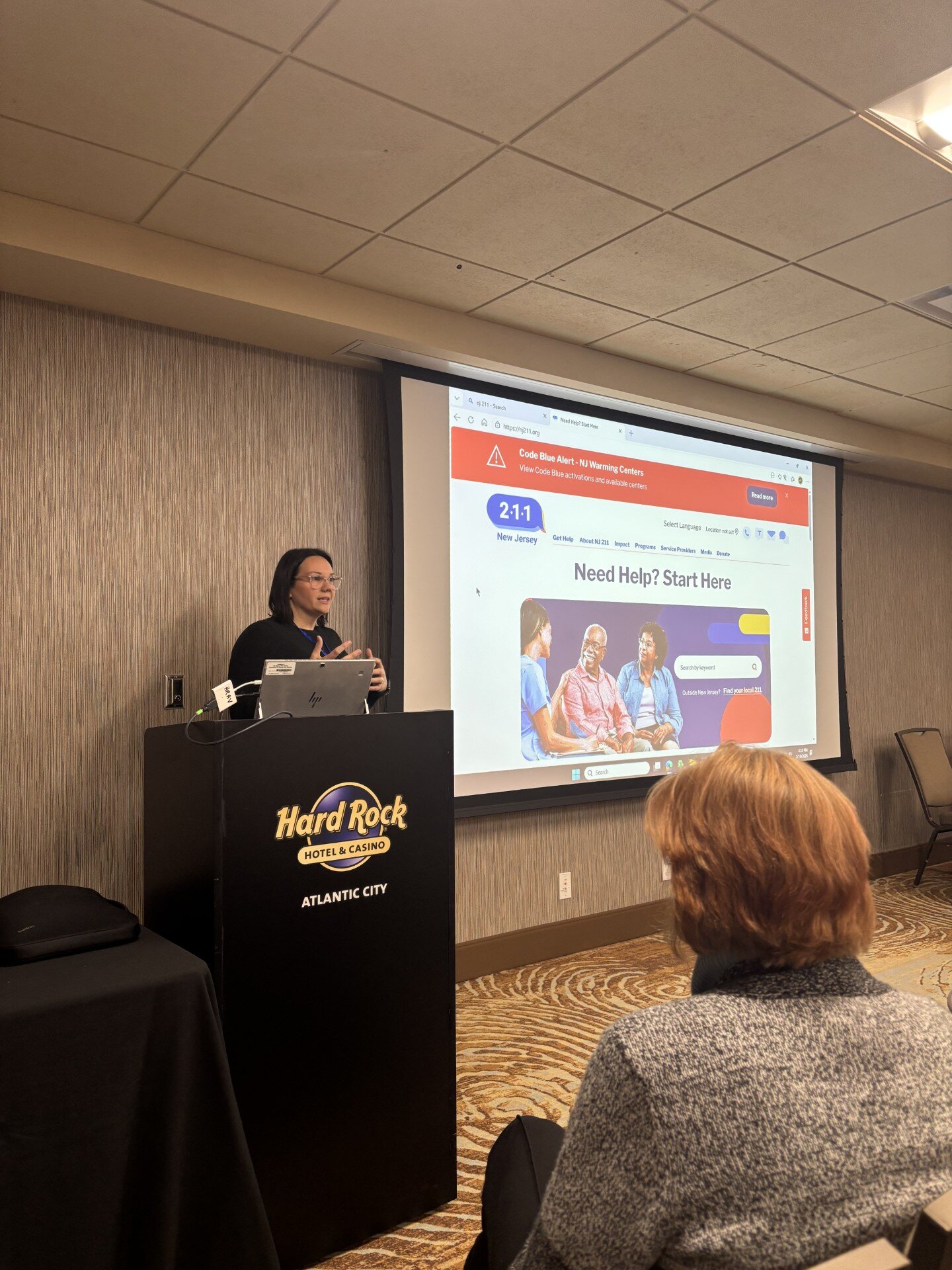 woman standing behind podium presenting information