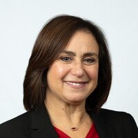 woman smiling with red shirt and black jacket